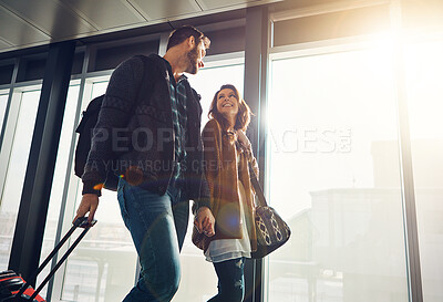 Buy stock photo Holding hands, luggage and travel with couple in airport together for overseas journey, trip or vacation. Love, smile or walking with man and woman tourist in lobby, pulling suitcase for boarding
