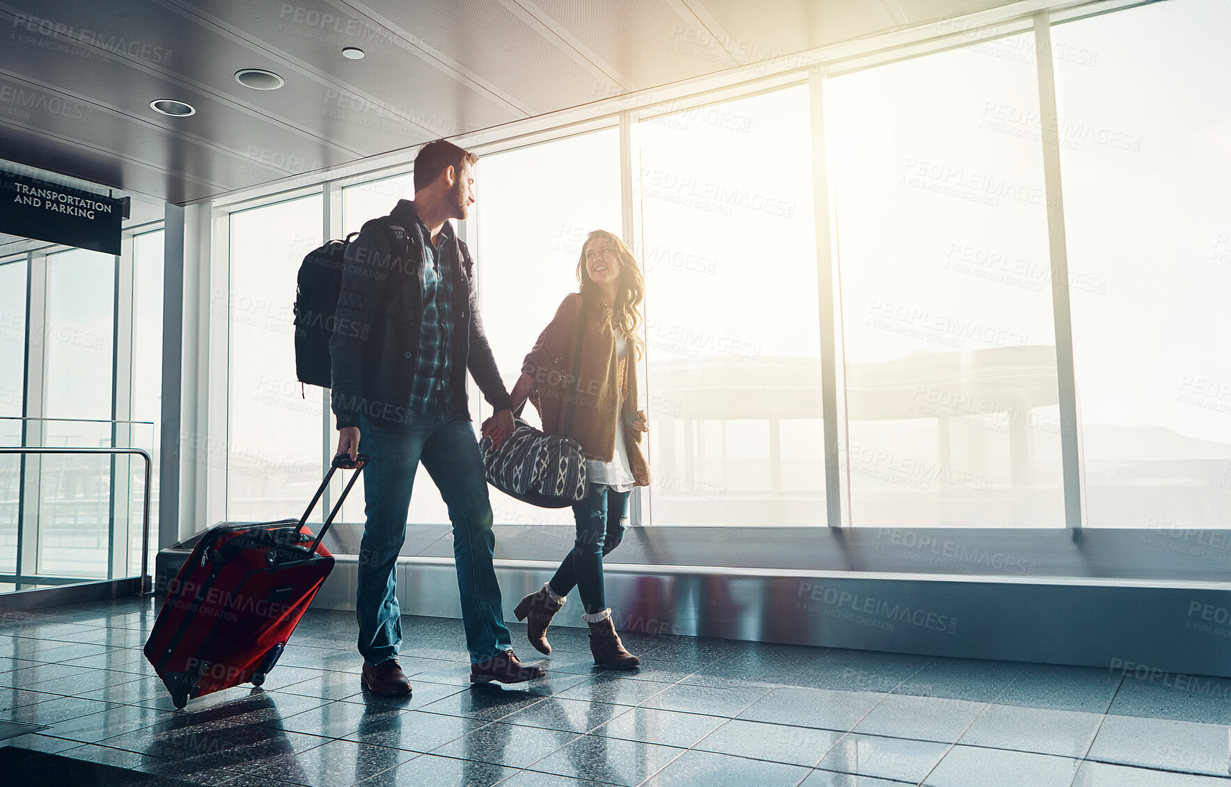 Buy stock photo Luggage, travel and walking with couple in airport together for overseas journey, trip or vacation. Holding hands, love or smile with man and woman tourist in lobby, pulling suitcase for boarding