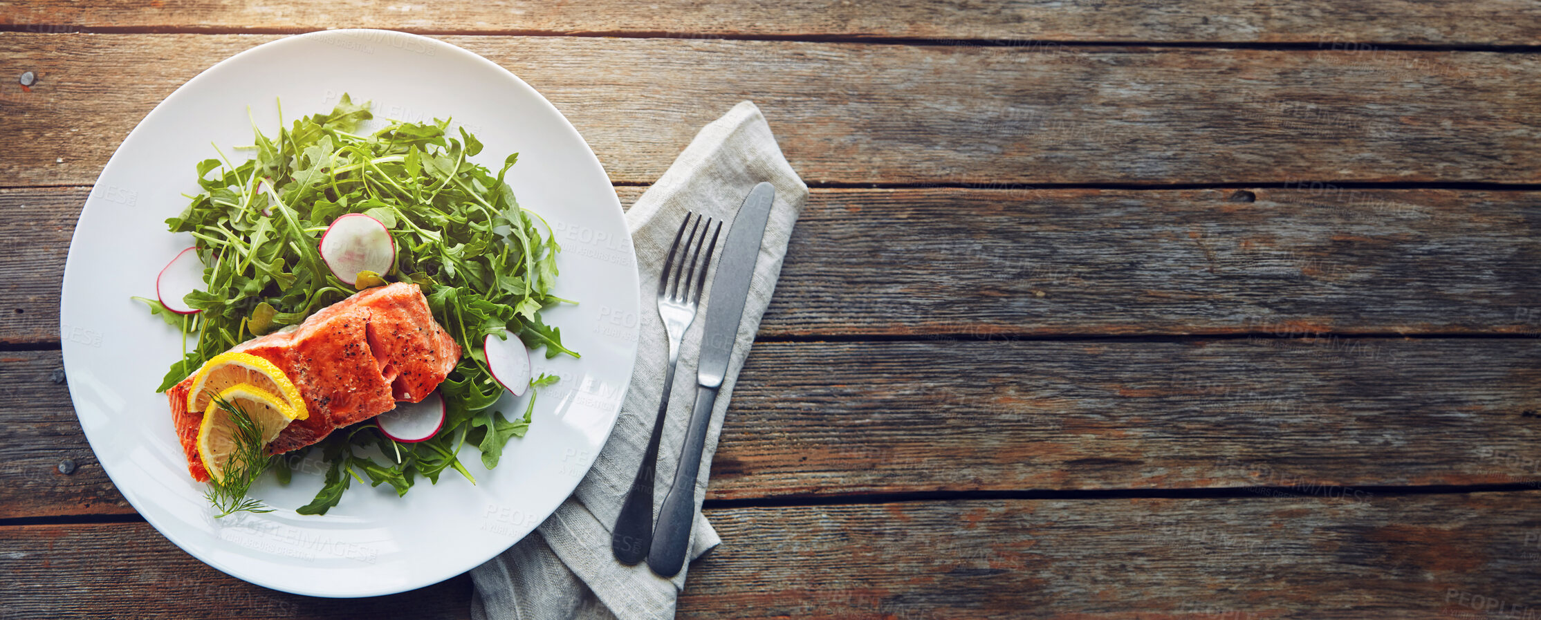 Buy stock photo Cutlery, napkin and salmon with salad on plate for healthy, wellness and nutrition fine dining cuisine. Food, mockup and gourmet fish, rocket leaves and radish with lemon on wooden table from above.