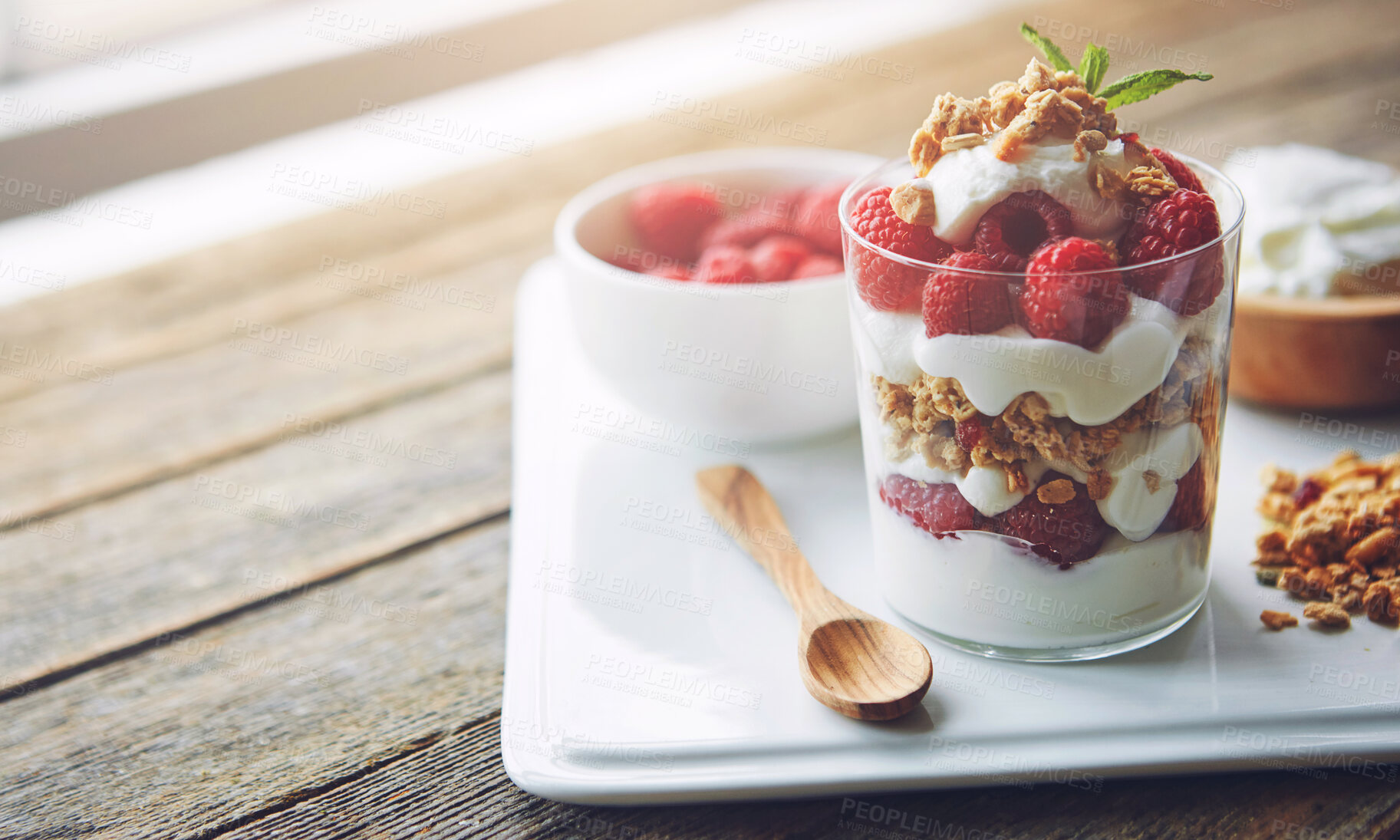 Buy stock photo Breakfast, glass and muesli with serving tray on wooden table for diet, health or nutrition. Food, fruit or strawberry with cream and oats in bedroom of home or hotel for hospitality and hunger