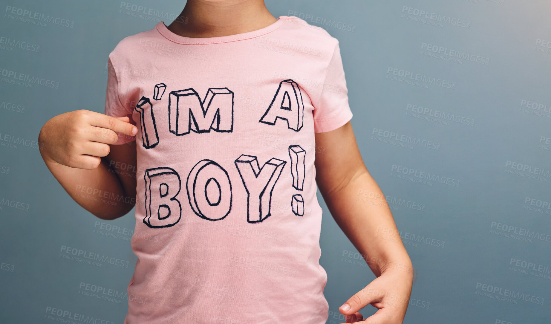 Buy stock photo Hands, child and point at text on shirt for gender identity, style and fashion model by blue background. Boy, toddler and kid with pink clothes for choice, learning and show print with affirmation