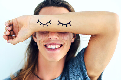 Buy stock photo Person, happy and arm covering eyes with shy, eyelash and emoji isolated on white background. Playful, smile and joyful with hiding face, funny or embarrassed gesture with laugh expression in studio.