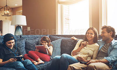 Buy stock photo Family, children and parents in lounge, watching tv and streaming on tablet with bonding in living room. Mother, dad and kids with headphones, popcorn and comedy to relax with film on sofa at house