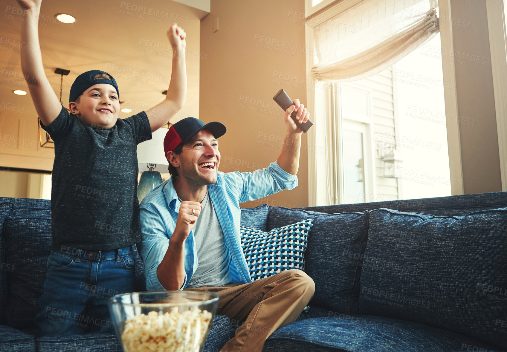 Buy stock photo Television, kid and man with success on sofa for network, streaming and watching sports together. Son, dad and popcorn with tv remote in fist for celebration, bonding and live broadcast of match