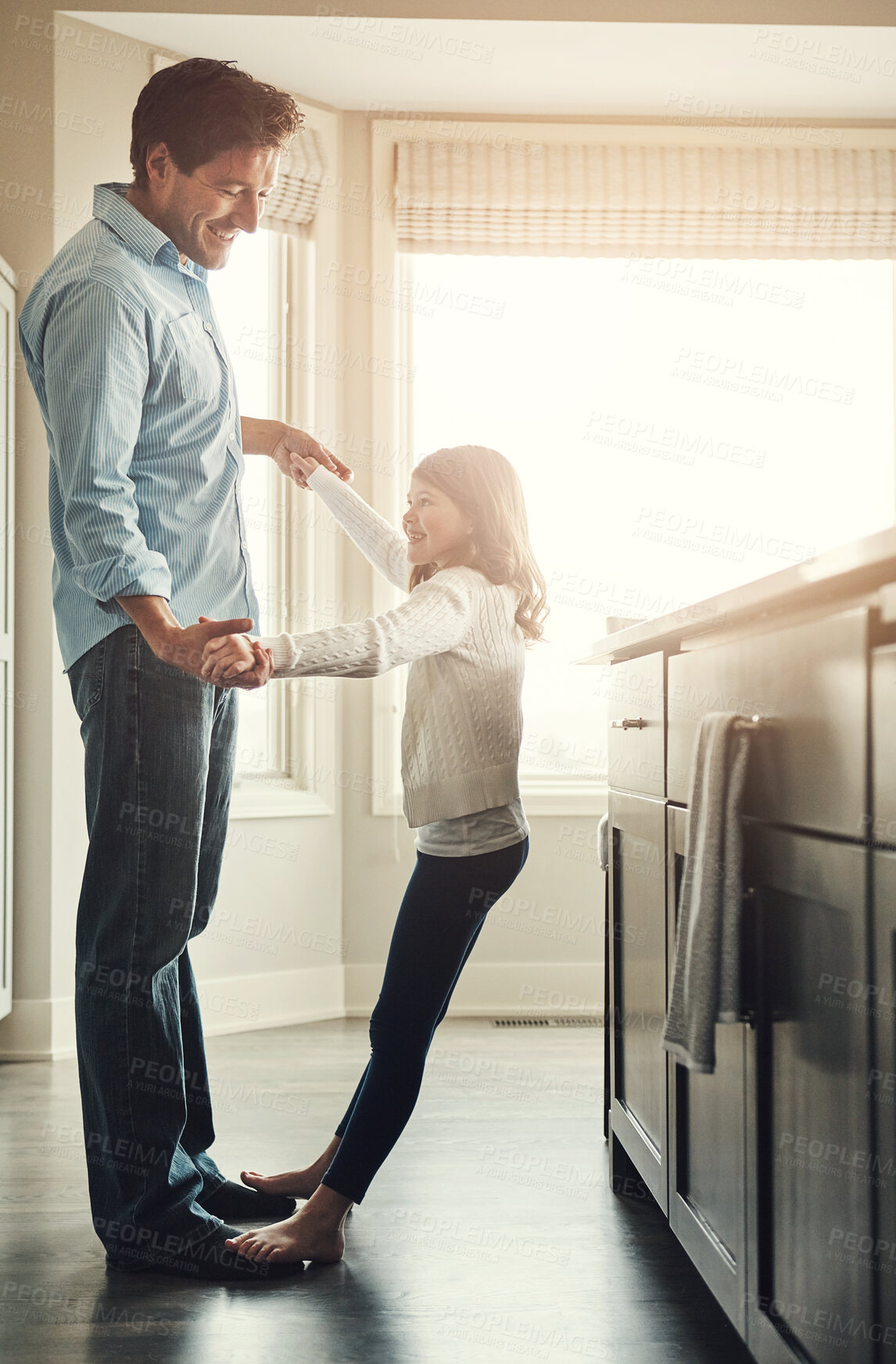 Buy stock photo Dancing, home and child on feet of father listening to music, playlist or radio in kitchen together. Smile, fun and happy dad teaching girl kid to groove for bonding on weekend in family house.