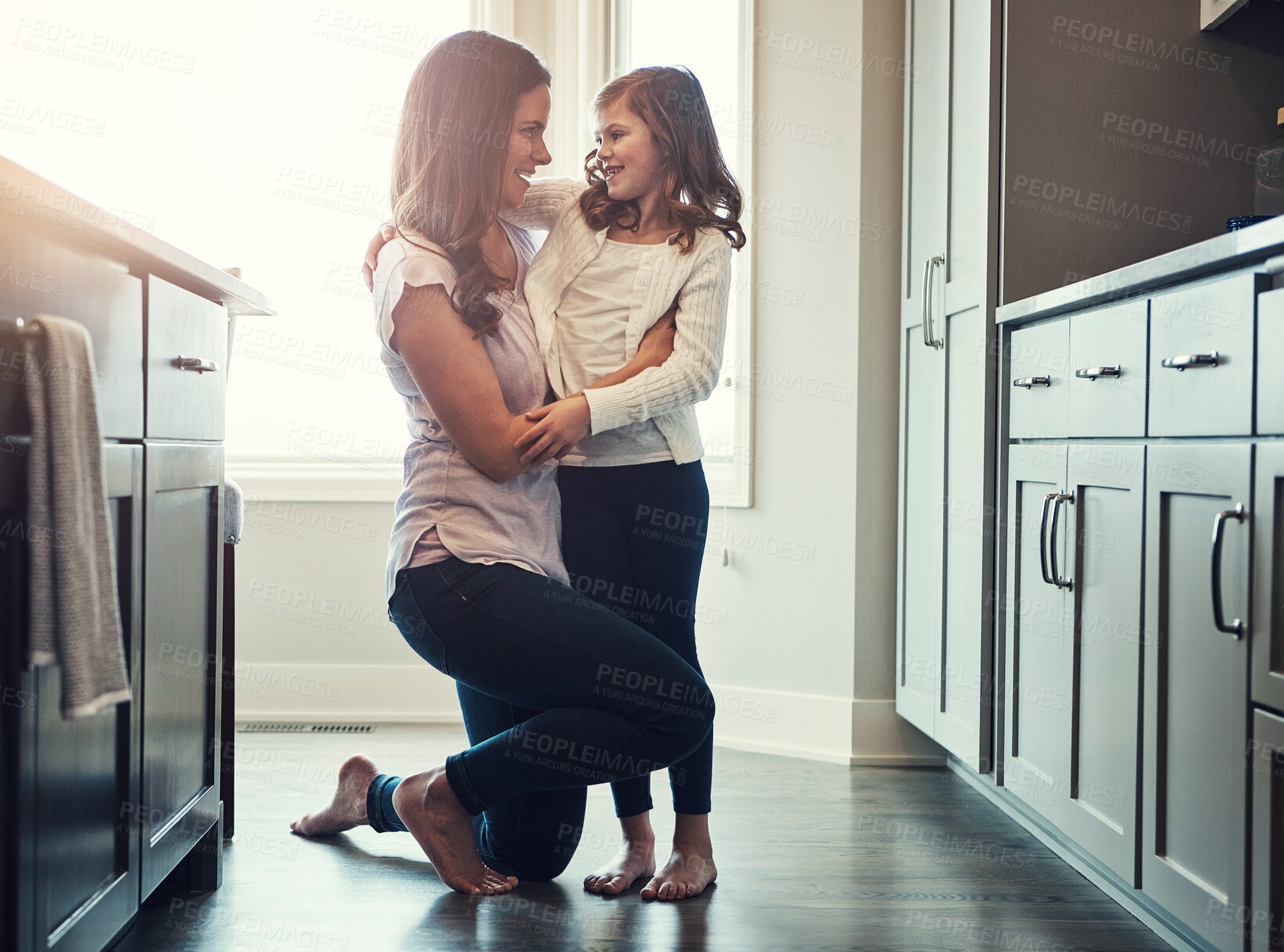 Buy stock photo Love, mother and hug for daughter, kitchen and bonding in weekend, house and kid with smile for parent. Home, child and mom with embrace, care and together in morning, peace or happiness in apartment
