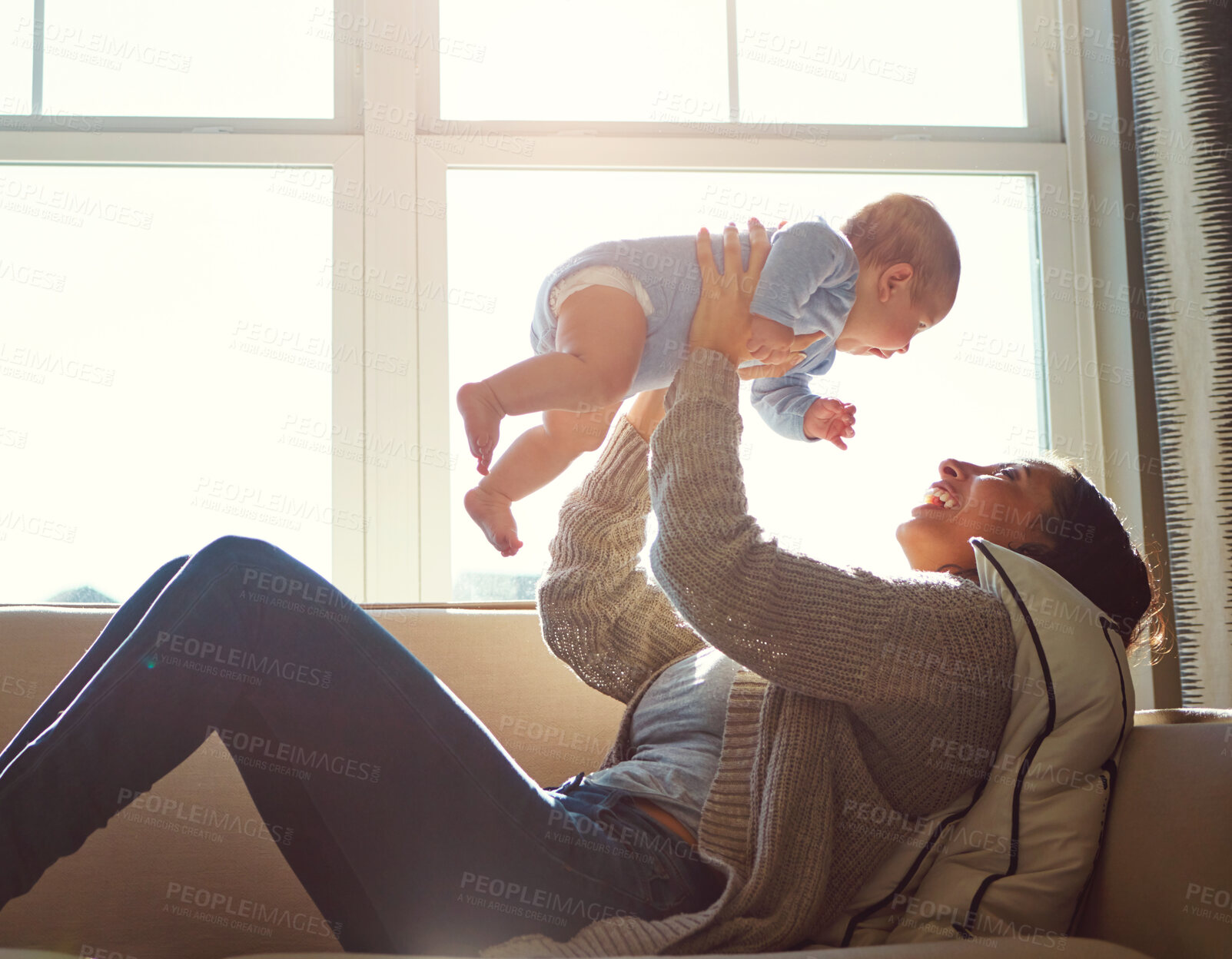 Buy stock photo Happy, mother and baby on sofa playing on weekend for love, bonding and relationship development in home. Care, woman and child together on couch in summer for safety, support or relax in living room