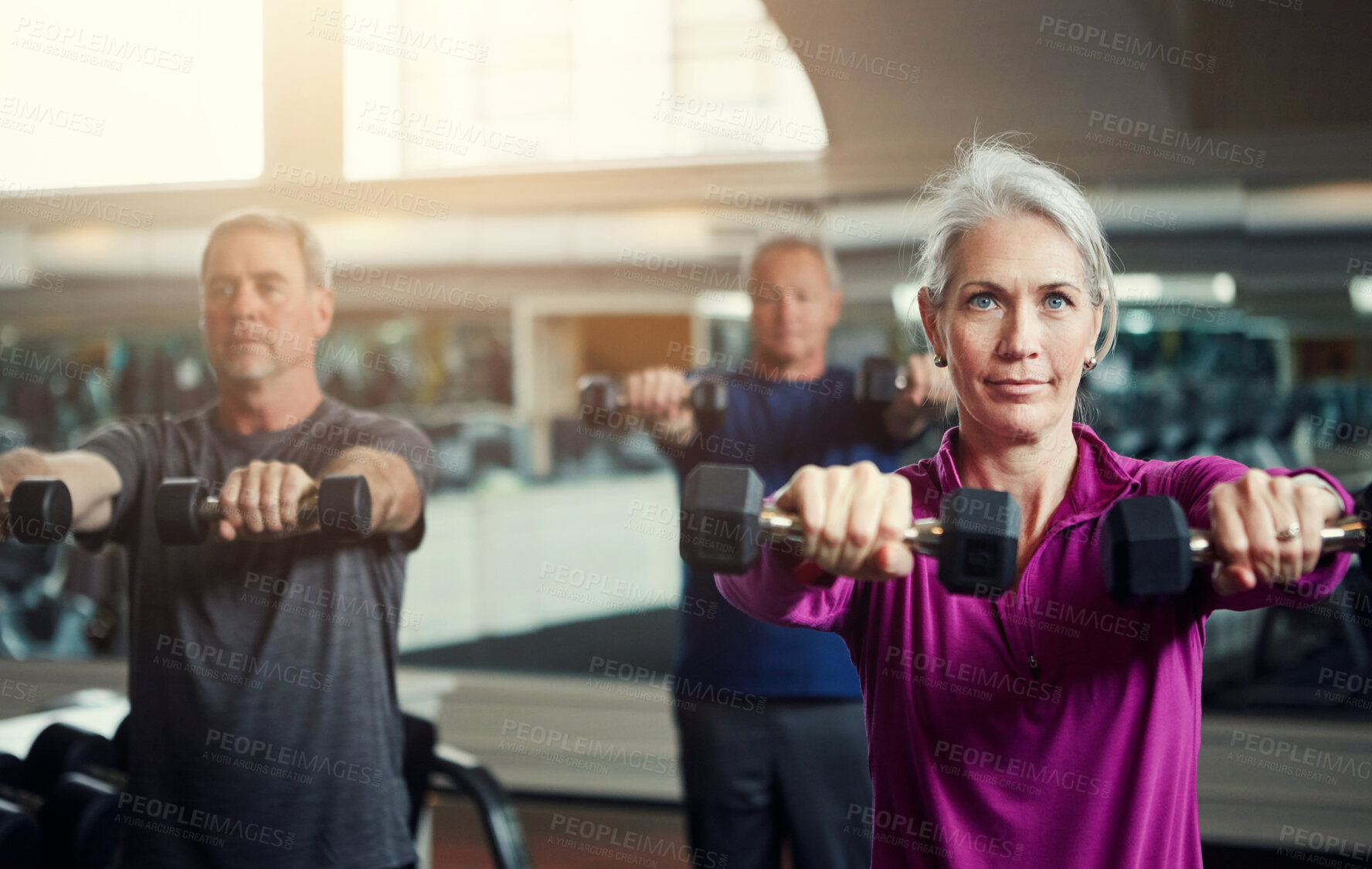 Buy stock photo Mature group, woman and dumbbell in class for fitness,  coaching and muscle development in gym. Senior people, men and exercise for arms, health and happy for weightlifting workout at wellness club