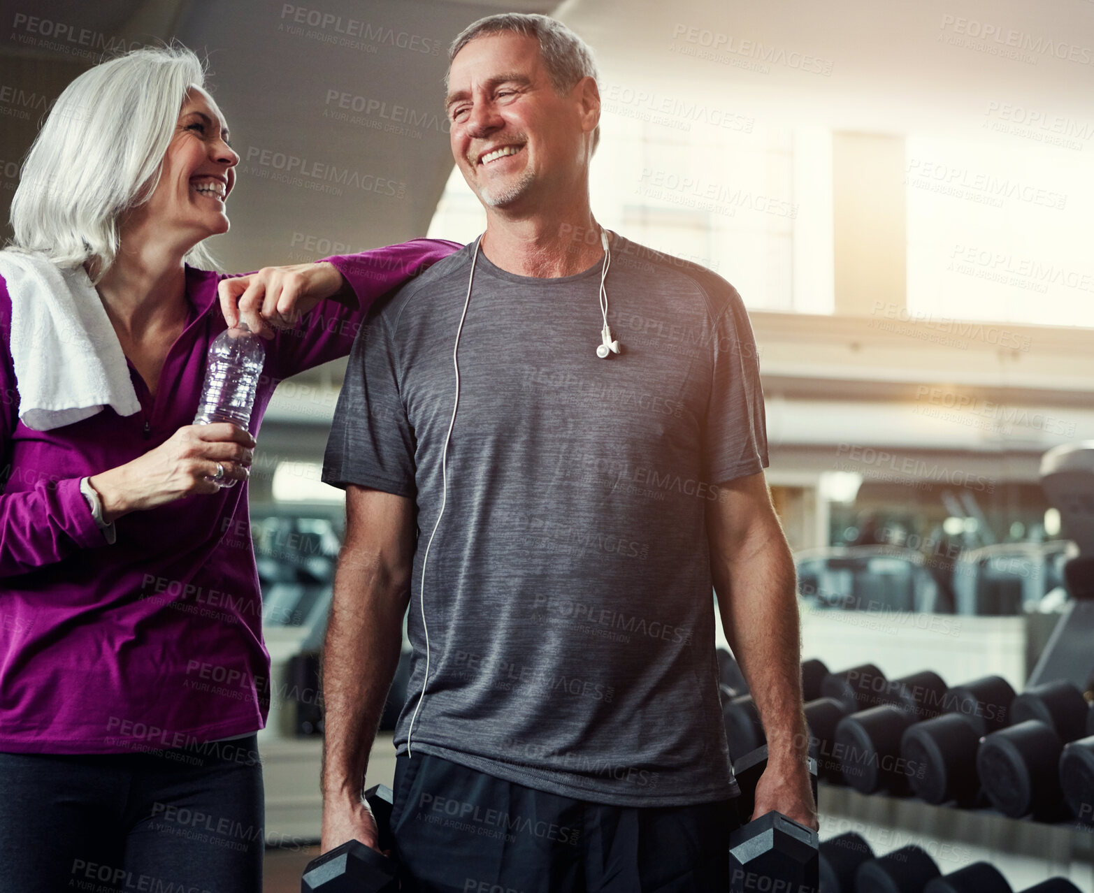 Buy stock photo Mature couple, fitness and bottle with gym, smile and dumbbell for training, conversation and exercise. Man, woman and happy together for talking, workout and motivation with water at wellness club