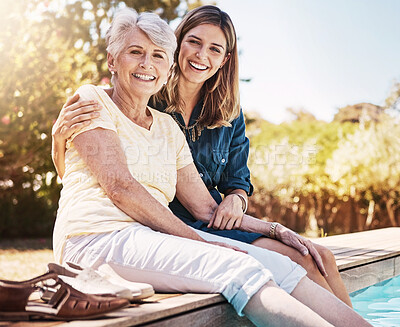 Buy stock photo Mother, daughter or happiness by swimming pool for wellness, hug or relax with lens flare in garden. Senior mom, woman or outdoor with smile for bonding, family with embrace or love and feet in water