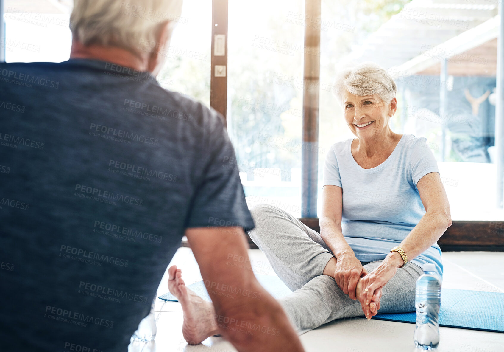 Buy stock photo Fitness, senior people and warm up in yoga studio for flexibility, rest and recovery. Happy, couple and foot rub or stretching for health, relaxation and rehabilitation in gym with light flare