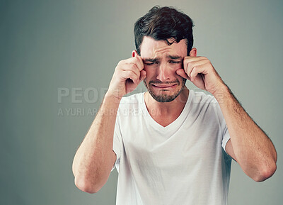 Buy stock photo Man, hands and crying face in studio, upset and disappointed emoji for depression or mental health crisis. Emotional, background and male person with sad expression, overwhelmed anxiety and unhappy