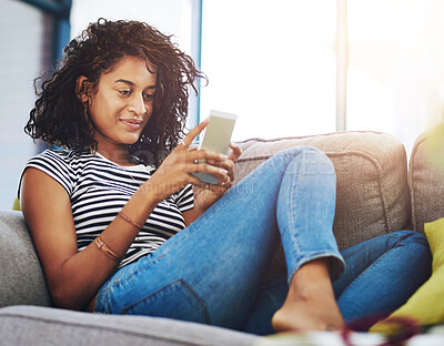 Buy stock photo Woman, smartphone and browsing on sofa in living room with social media or app for relax on weekend.Person, smile and house with internet for communication or search with blog, reading and texting.