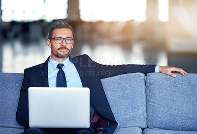 Buy stock photo Businessman, laptop and portrait on sofa in office, serious and corporate company with tech for networking. Digital, website review and employee on couch, email and relaxing in professional workplace