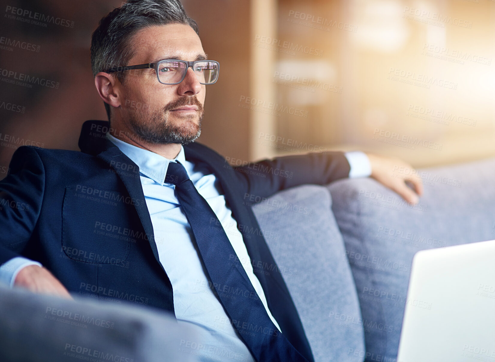 Buy stock photo Sofa, relax and businessman with thinking in office for legal case, problem solving and solution. Lawyer, smile and professional person with laptop at law firm for research plan, information and idea