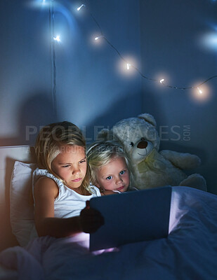 Buy stock photo Tablet, bedroom and children in home at night for streaming movie, video or cartoon together. Digital technology, girl or kids in bed for game or sisters reading story online to relax with teddy bear