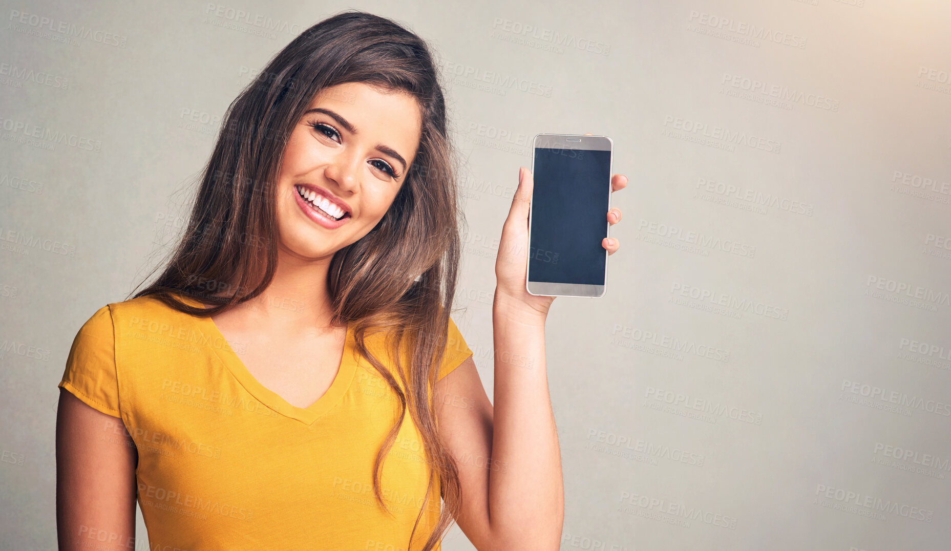 Buy stock photo Portrait, woman and display of phone in studio with mockup space for advertising, marketing or promotion. Smile, technology and female person presenting cellphone screen isolated by gray background.