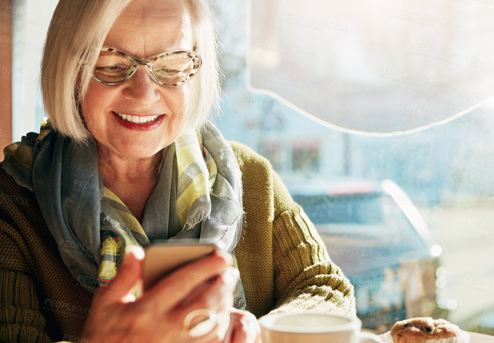 Buy stock photo Senior woman, smile and browsing smartphone in cafe with laugh for internet or social media with relax. Funny, post and tech savvy in restaurant with coffee, muffin and sunshine in retirement