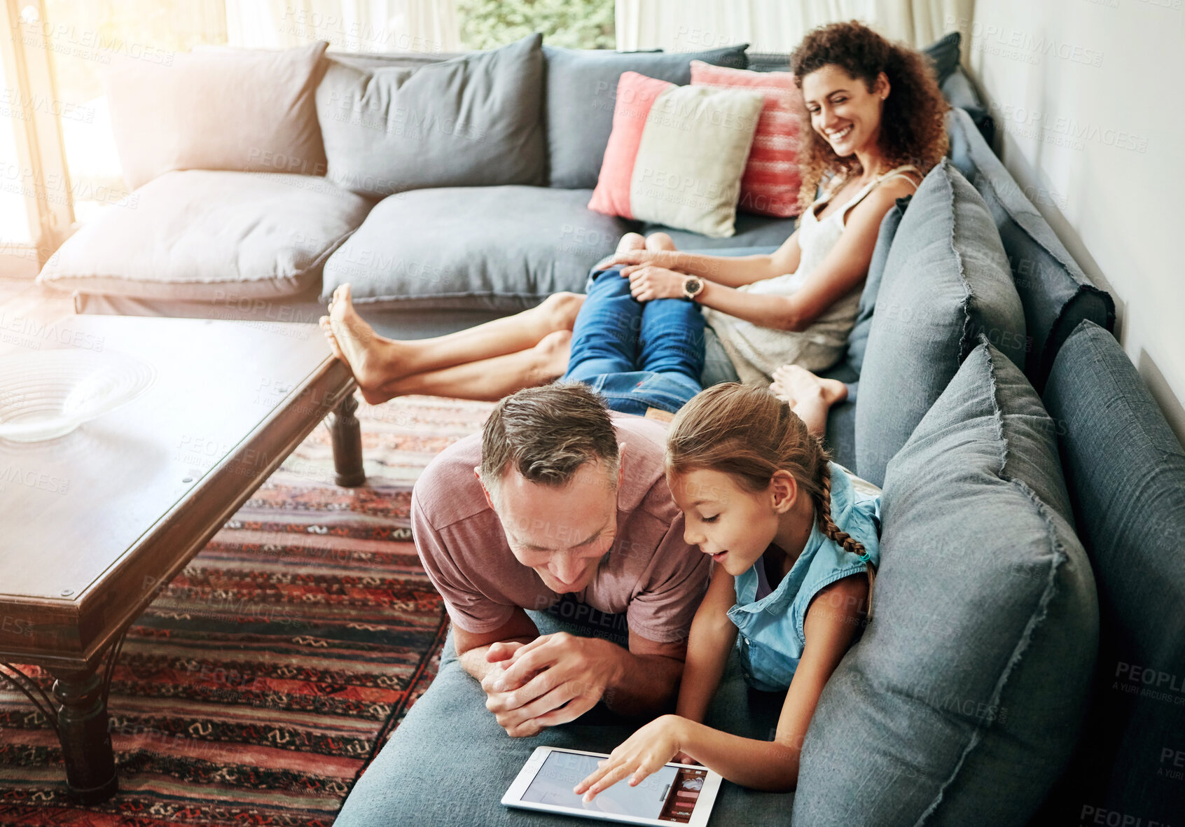 Buy stock photo Mother, father and child with tablet in watching on weekend, break at home for e learning or gaming. Happy people, lounge and relax in together for bonding as parents for growth, development and love