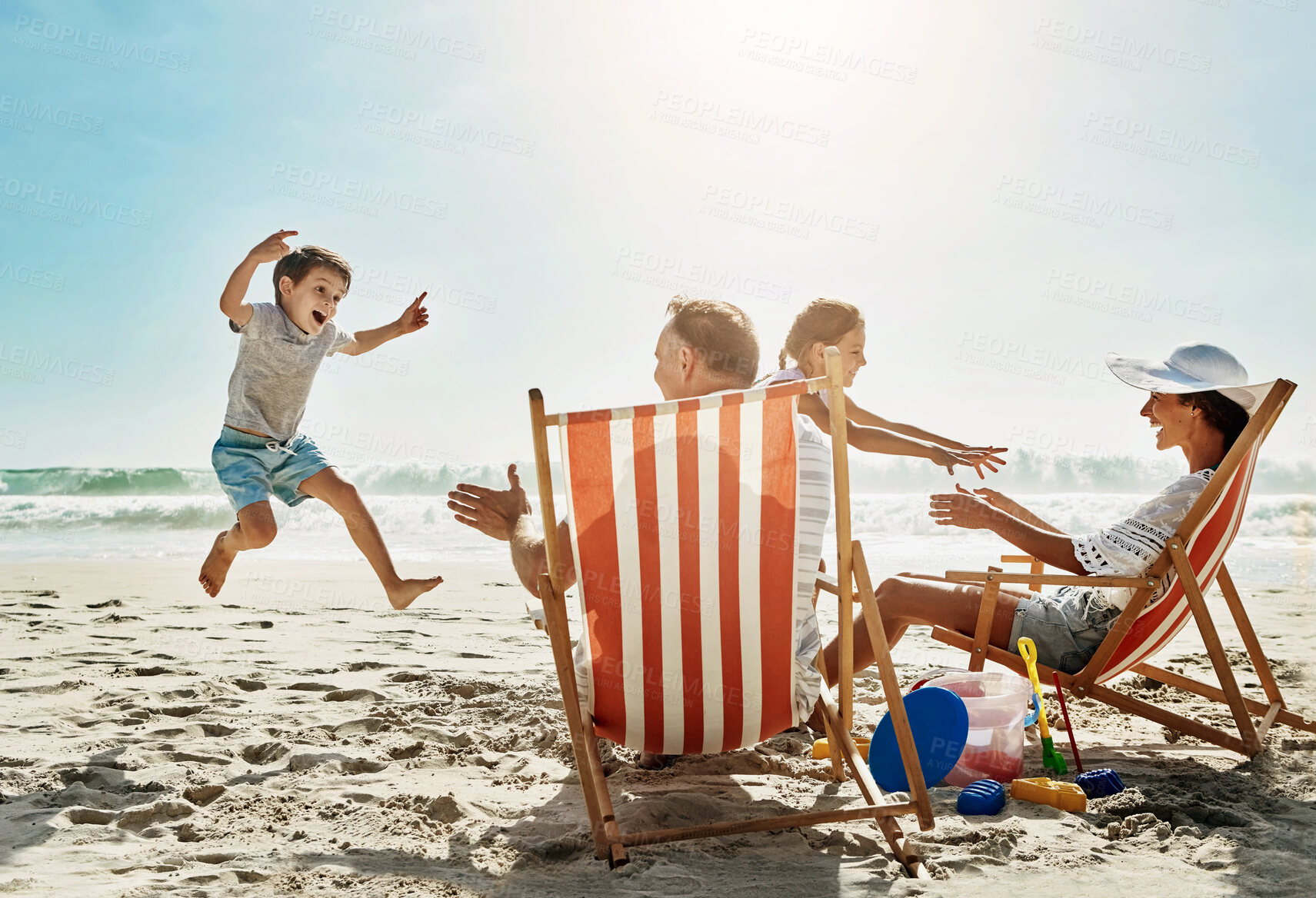 Buy stock photo Beach, sunshine and family with vacation, happiness and excited with getaway trip, chairs and playful. People, parents and kids with holiday, seaside and summer with water, love or travel with energy