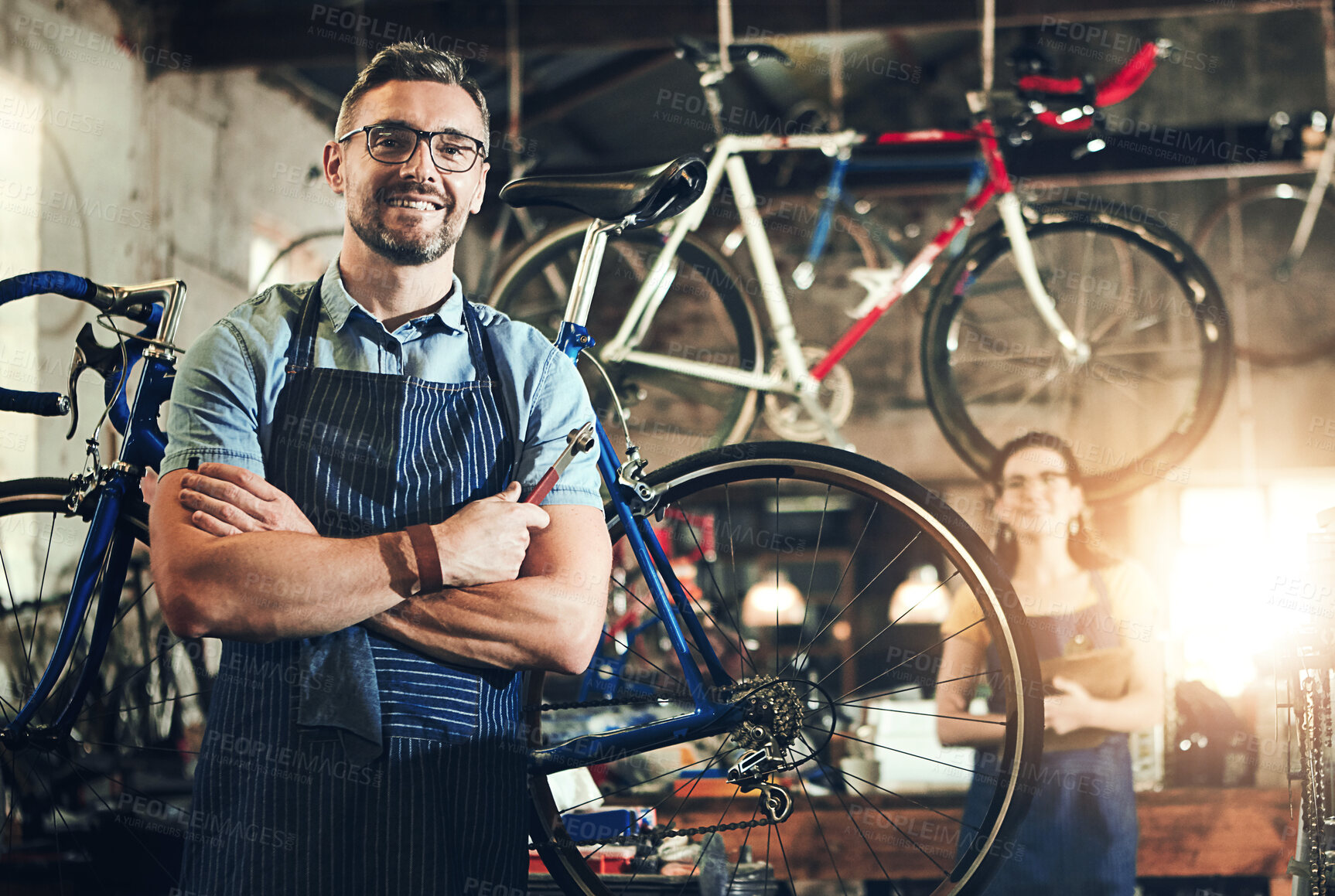 Buy stock photo Man, portrait and arms crossed at work in bicycle repair shop or maintenance garage. Bike, mechanic and service with a professional handyman for startup, small business and workshop for fixing