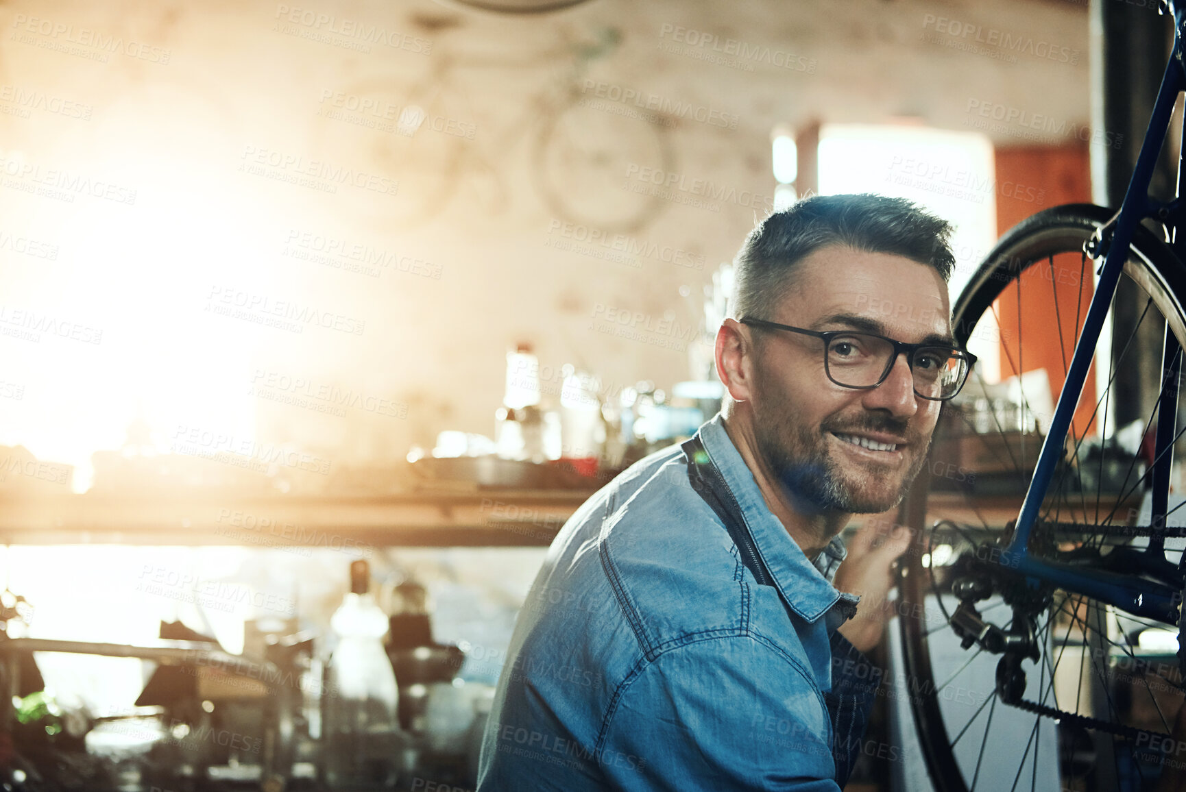 Buy stock photo Portrait, smile and man with bicycle for mechanic career, business owner and working in maintenance garage. Mature male person, technician and bike inspection in cycling workshop for wheel repair