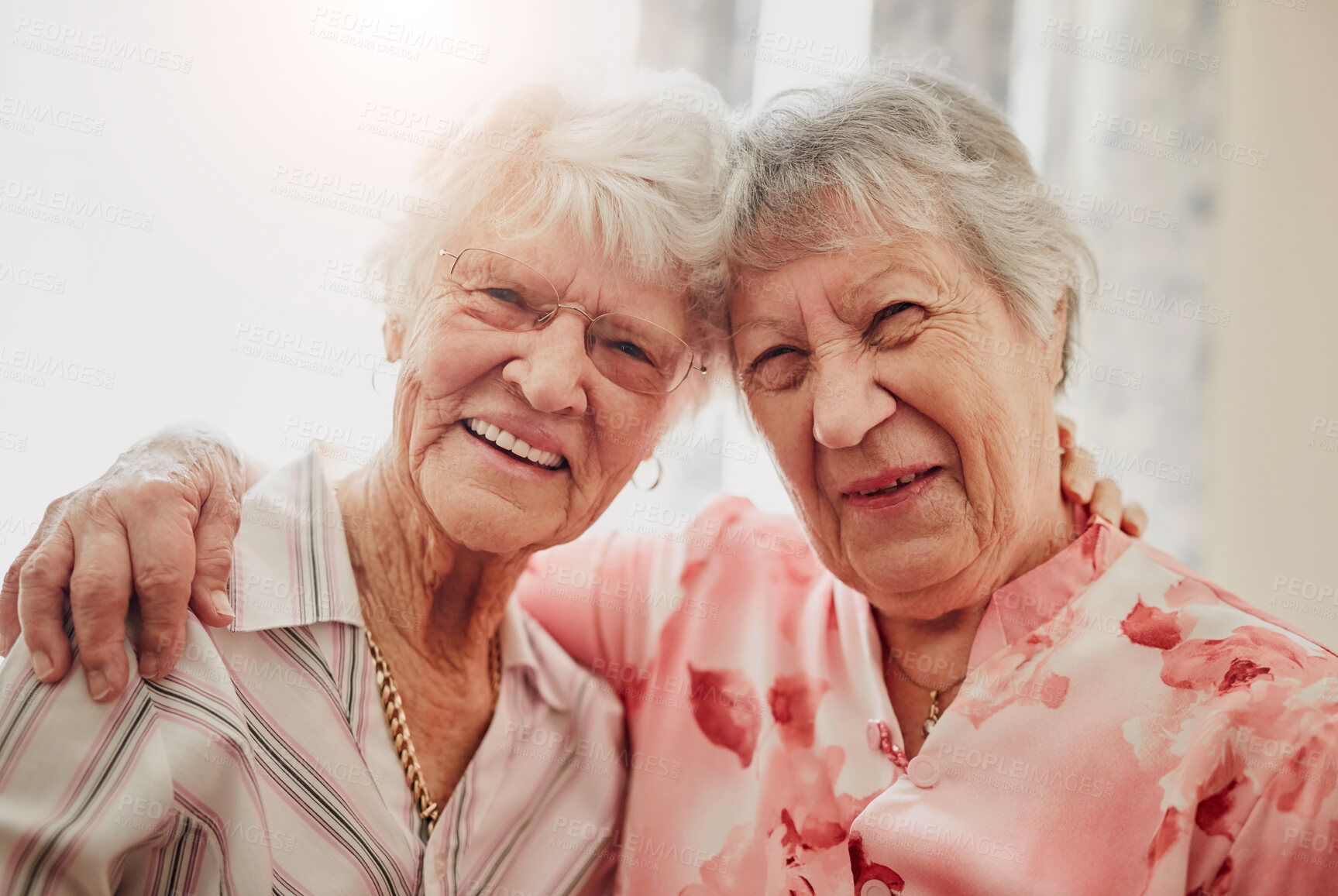 Buy stock photo Elderly women, friends and hug in house with smile in portrait for care, love or bonding with reunion. Senior people, embrace and happy for connection in morning, lounge or together in nursing home