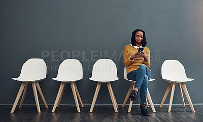 Buy stock photo Business woman, phone and waiting room for interview, recruitment or human resources communication. African worker typing on mobile, chat or contact for job search or news on chair by wall background