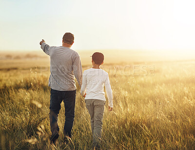 Buy stock photo Back, field and father with son, walking and adventure with sunshine, getaway trip and bonding together. Family, single parent and dad with kid, boy and childhood with weekend break, nature or travel