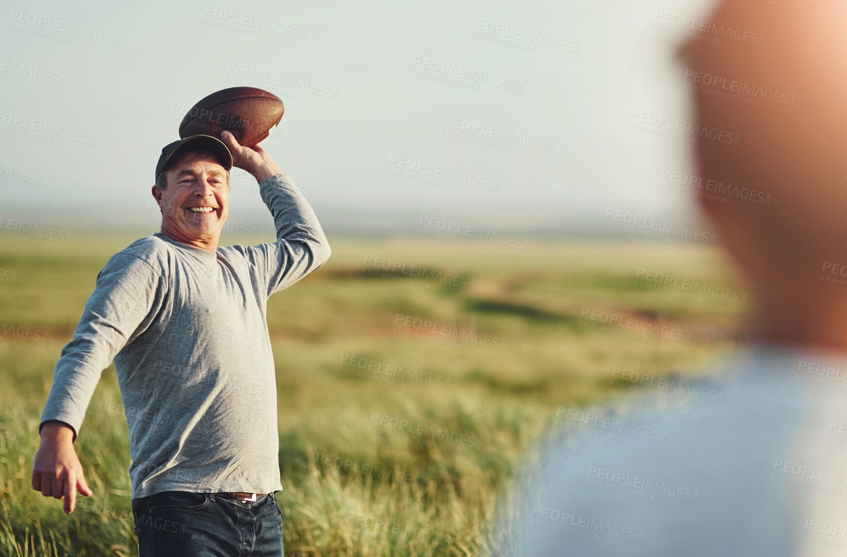 Buy stock photo Son, man and sports with football on grass field for outdoor exercise, teaching and child development. Happy, dad and smile with kid in nature for throw, practice and bonding together on fathers day