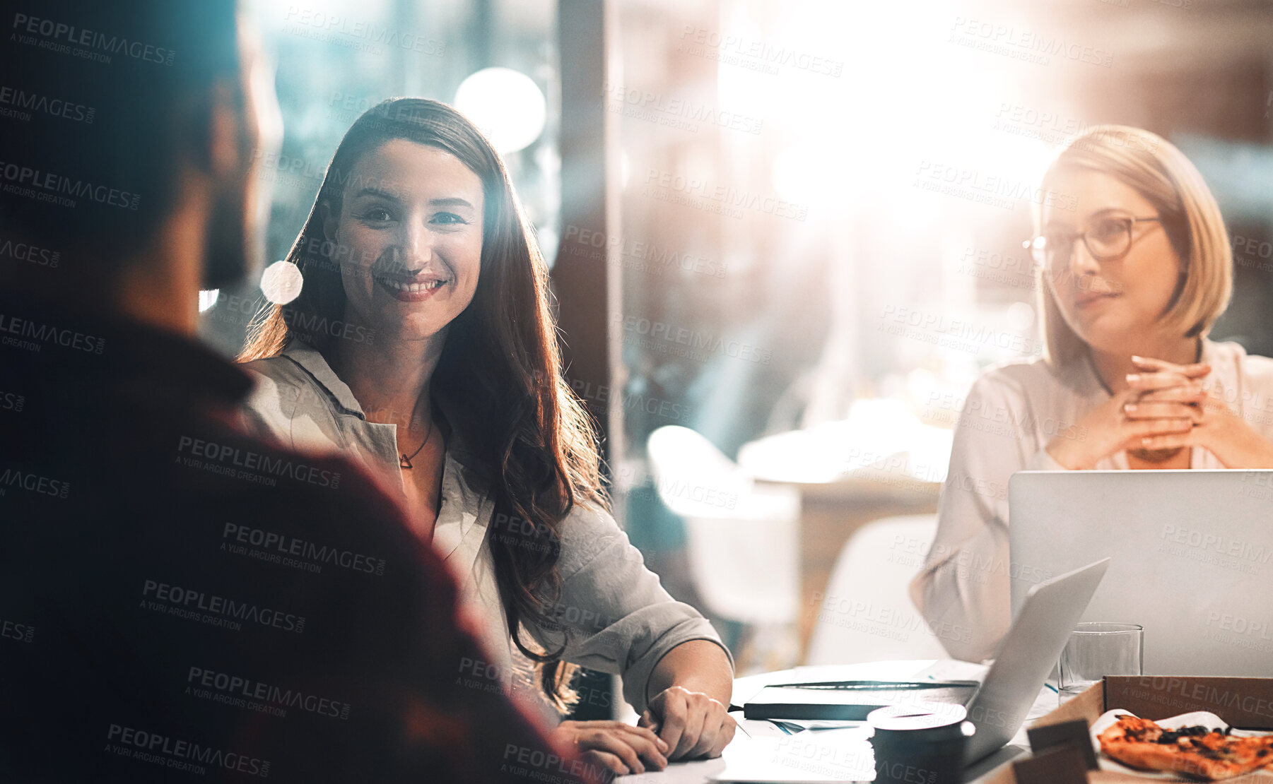 Buy stock photo Smile, group and business people planning, discussion or brainstorming on laptop in startup at night. Team, collaboration and project strategy in meeting for creative editor with pizza on deadline