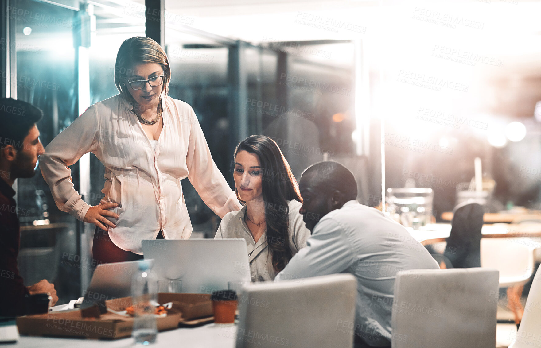 Buy stock photo Night, management and business people with laptop in meeting for creative project, deadline and review. Web design, employees and team with mentor in office for ux information, feedback and overtime