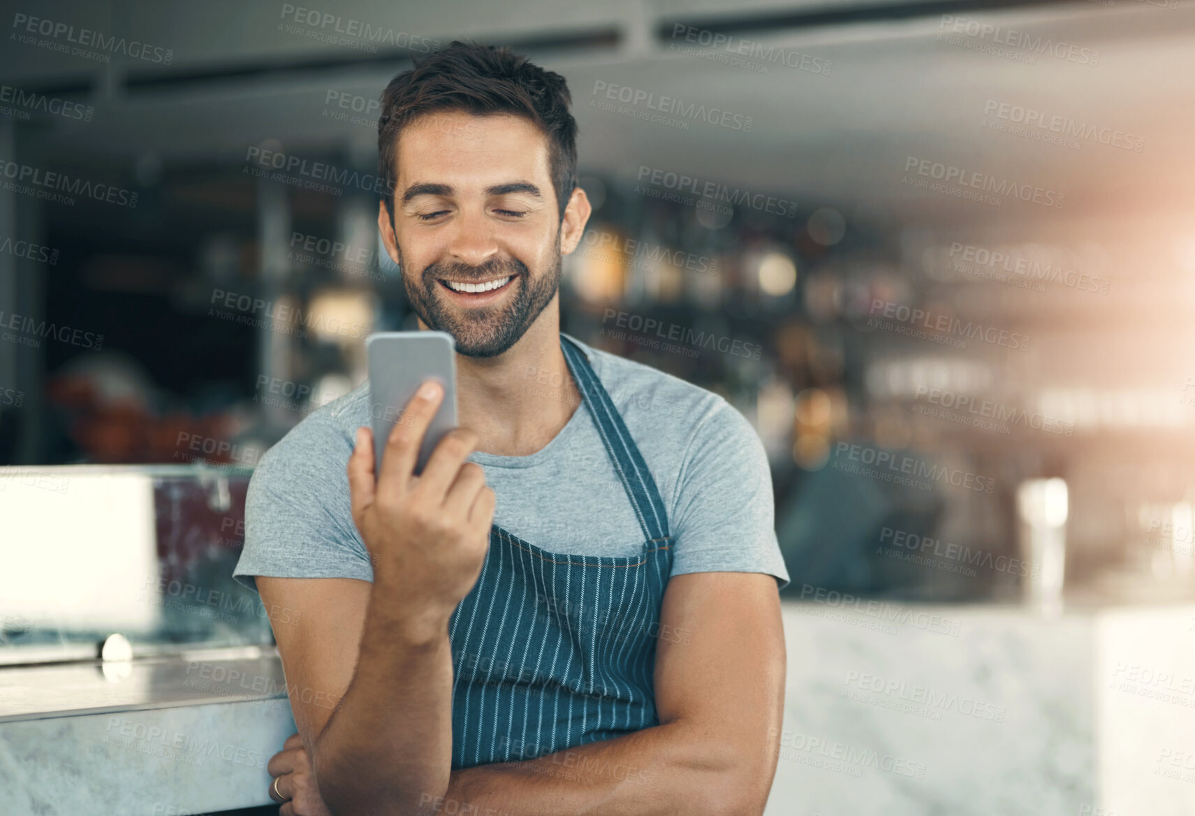 Buy stock photo Barista, man and mobile phone in cafe with apron for  communication, networking or restaurant app. Connection, small business owner and male person for social media, browsing internet or online order