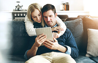 Buy stock photo Couple, tablet and hug or online in home with search for holiday destination or social media browsing. People, smile and embrace on sofa in living room with bonding, discount offers on travel or love