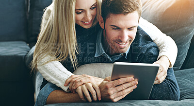 Buy stock photo Couple, tablet and hug or online in home with search for holiday, discount offers on travel or web streaming. People, smile and embrace in living room with bonding, social media browsing and support