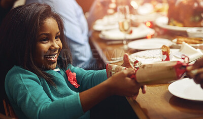 Buy stock photo Celebration, Christmas cracker and girl child at table in dining room of home for festive excitement. December, holiday or smile and cute kid in apartment with family together for social gathering