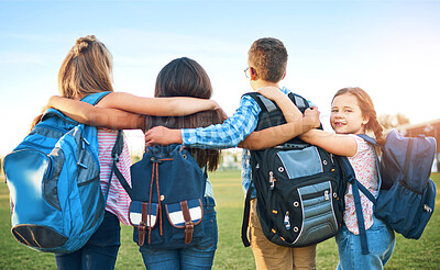 Buy stock photo School kids, group and back with hug, outdoor and together with support, solidarity and development. Children, girl and portrait for learning, education and future with backpack on lawn at academy