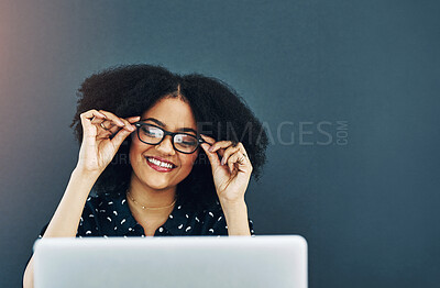 Buy stock photo Glasses, laptop and smile with designer woman in studio on blue background for web development. Computer, intelligence and mockup space with happy creative at work for education, growth or vision
