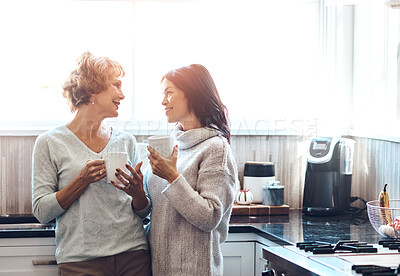 Buy stock photo Morning, coffee and mother with daughter in kitchen for conversation, talking and enjoy beverage together. Family, home and mature mom with happy woman with drink for bonding, relationship and love