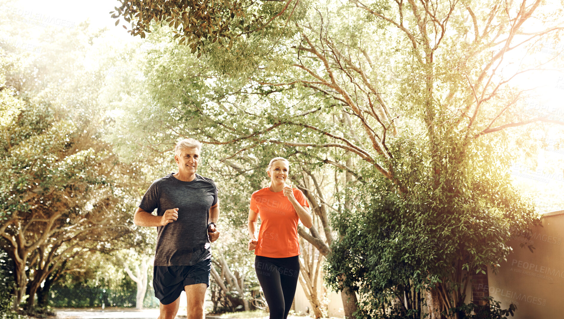 Buy stock photo Happy, senior couple and nature with running for fitness, cardio exercise and bonding together. Man, woman and smile with energy in sunshine for outdoor workout, healthy body and teamwork in sport