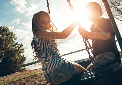 Buy stock photo Children, tyre swing and play in outdoor, bonding and friends at playground for game or adventure. Kids, lens flare and together for fun in backyard or freedom, siblings and connection on vacation