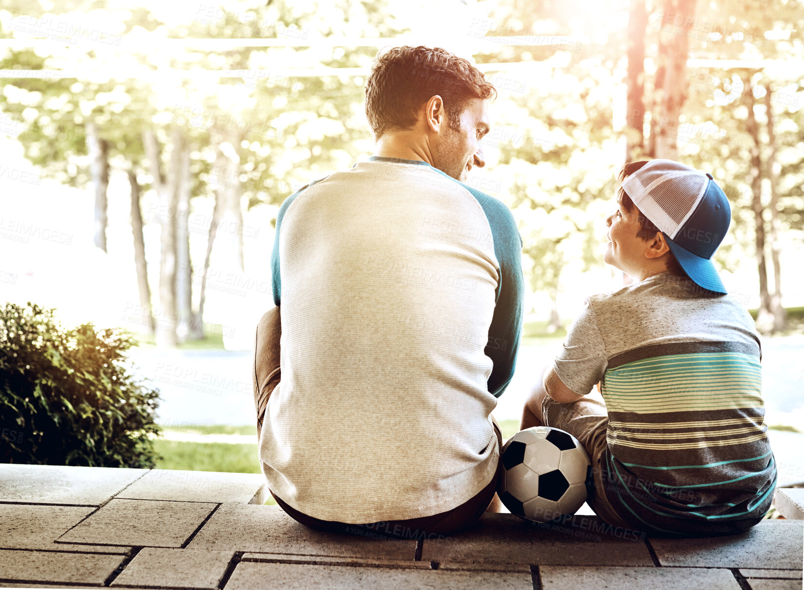 Buy stock photo Dad, kid and relax with soccer ball in backyard for outdoor sports, bonding and child development. Back, man and son outside home with smile for exercise, practice and happiness on fathers day