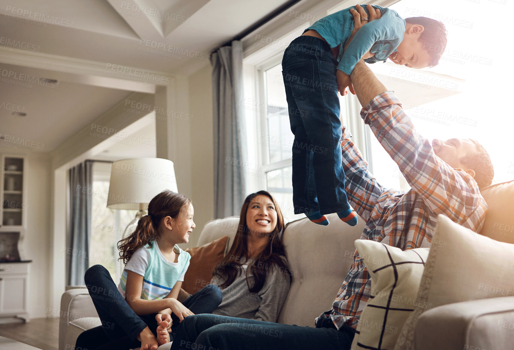 Buy stock photo Family, dad and airplane with son on sofa for fun, childhood memory and together with love or playful support. Father, boy and bonding in living room in home with mom or sibling, affection and happy.