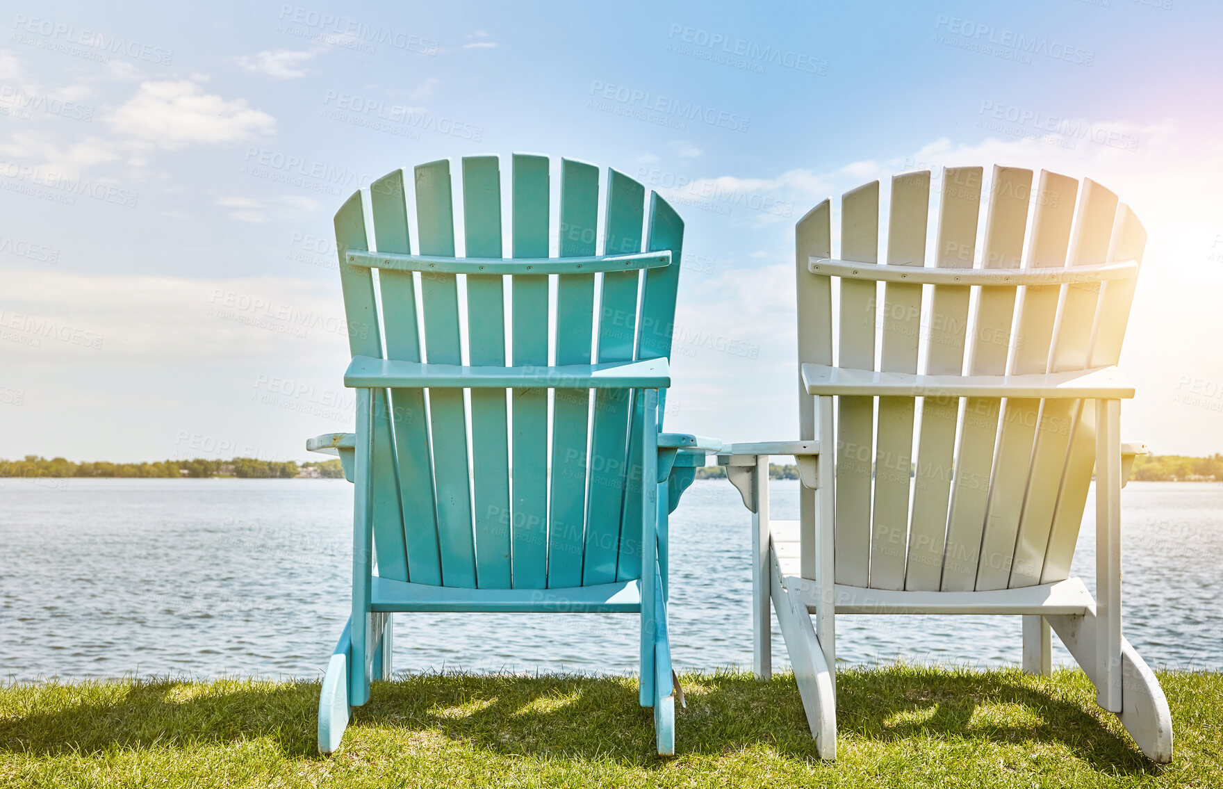 Buy stock photo Blue sky, sunshine and chair on grass at lake for environment, scenery and relax in summer. Clouds, nature and bench on outdoor field by water for sitting view, holiday and vacation in California