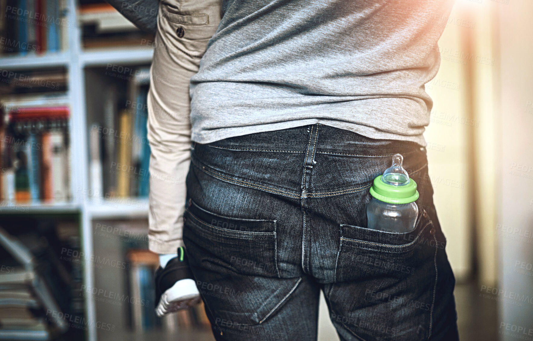 Buy stock photo Back, bottle in pocket and parent with child in living room of home for love, security or trust. Baby, family and jeans with person carrying kid in apartment for comfort, development or growth