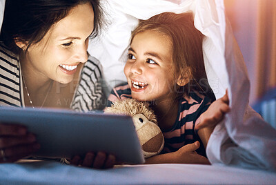 Buy stock photo Bedtime, storytelling on tablet with mother and daughter in blanket together for bonding at night. Happy, love or smile with woman single parent reading to girl child in bedroom of home for fantasy