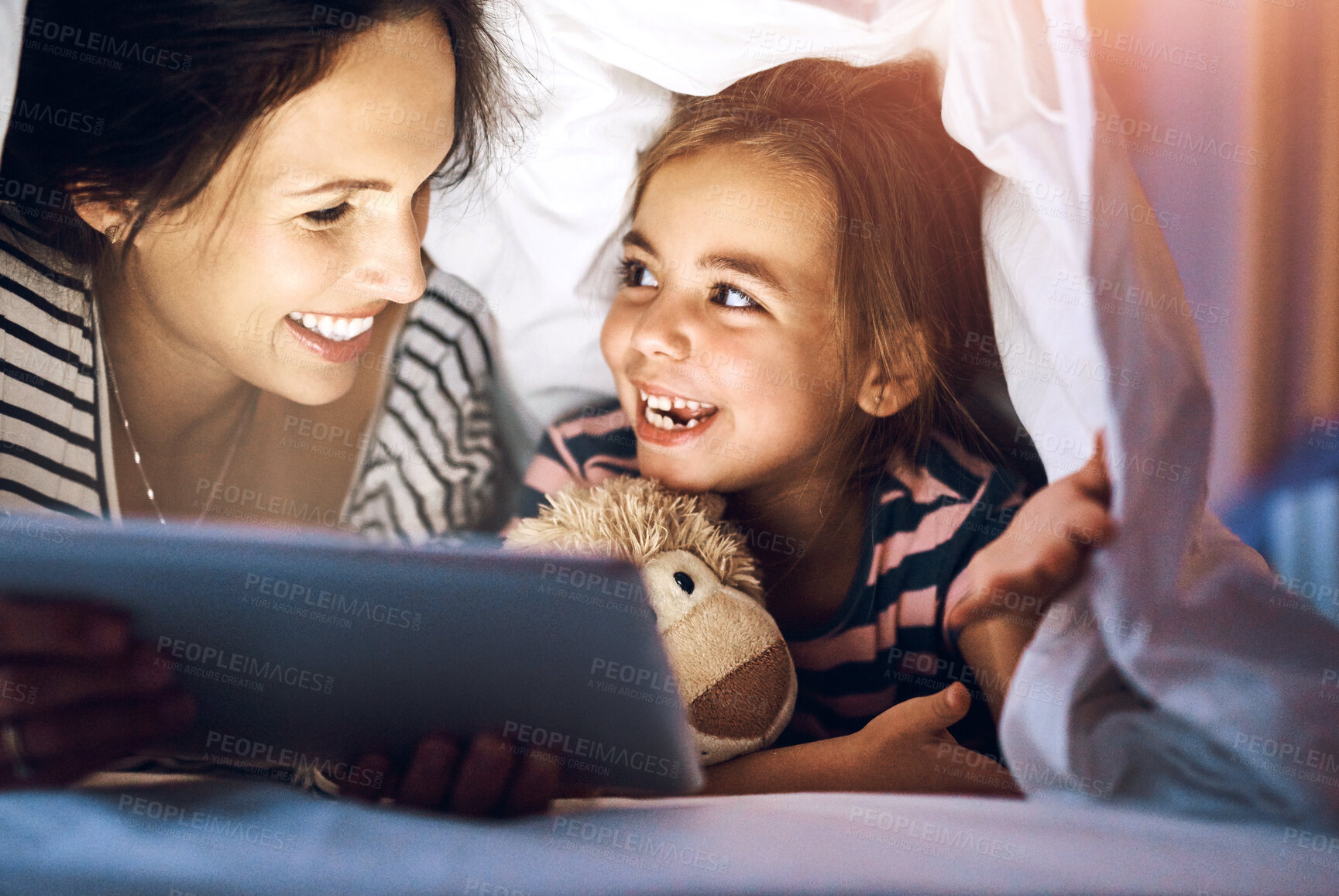 Buy stock photo Bedtime, storytelling on tablet with mother and daughter in blanket together for bonding at night. Happy, love or smile with woman single parent reading to girl child in bedroom of home for fantasy