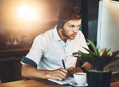 Buy stock photo Computer, headphones and writing with business man at desk in office for creative development. Music, streaming radio or web design and serious employee with notebook in workplace for research