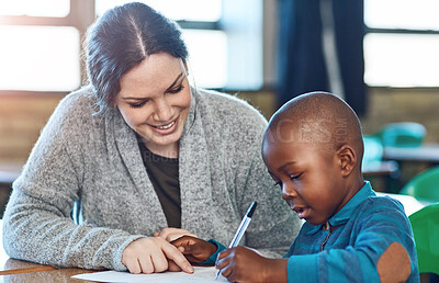 Buy stock photo Happy teacher, woman and help child writing in notebook for education, studying or knowledge in class. Kid, educator and student learning in lesson for development or support at kindergarten school