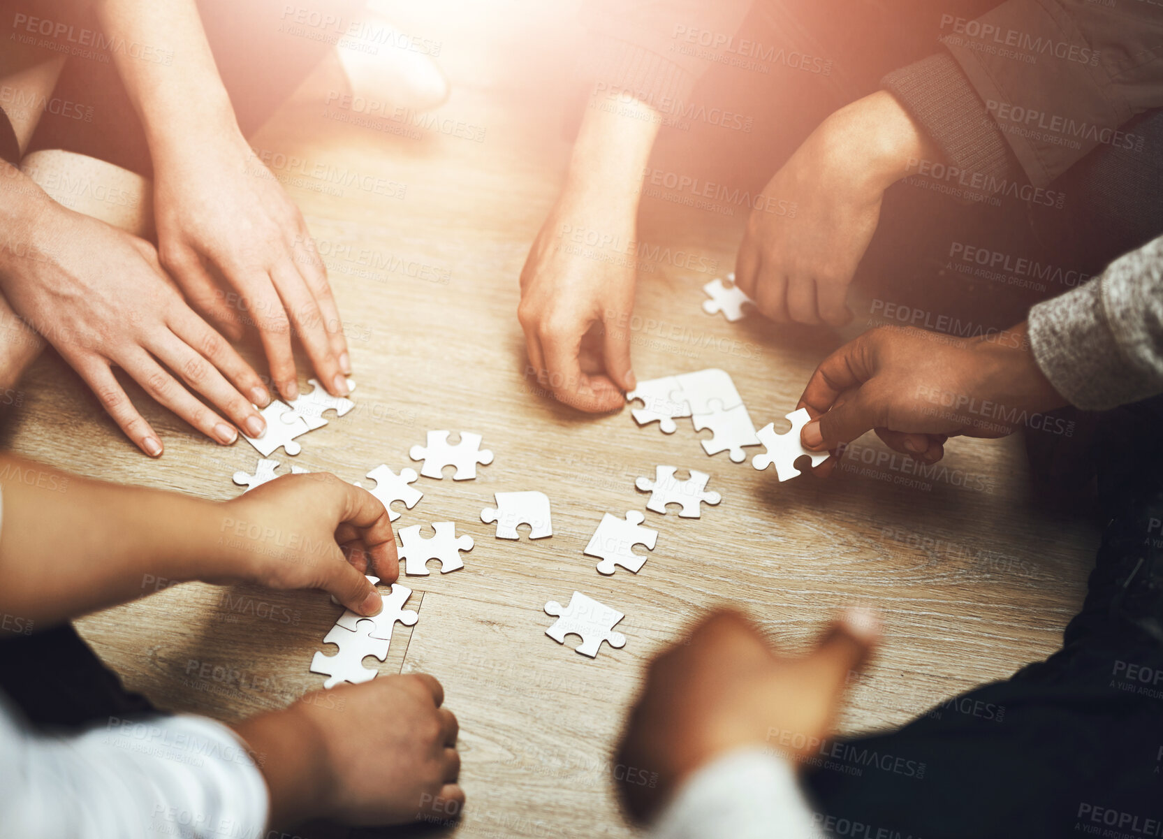 Buy stock photo Hands, puzzle and group in circle with strategy, problem solving and connection for synergy with people. Teamwork, link and solution in scrum, huddle or above for collaboration, community and jigsaw